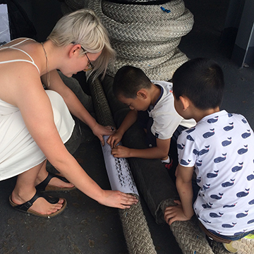 Anastasiia Palamarchuk making art from ship's rope with children