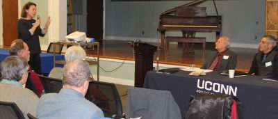 Christine Nelson, town planner for Old Saybrook, asks a question to panelists Mark Branse, second from right, and Jeff Caiola, far right, during the workshop.