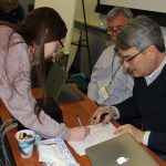 Sophie Smyth, captain of of the two Cranston High East teams, signs to verify the results of an early round in the competition.