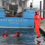Fishermen jump into the water to practice using their immersion suits.