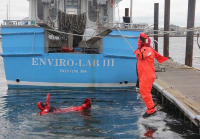 Fishermen jump into the water to practice using their immersion suits.