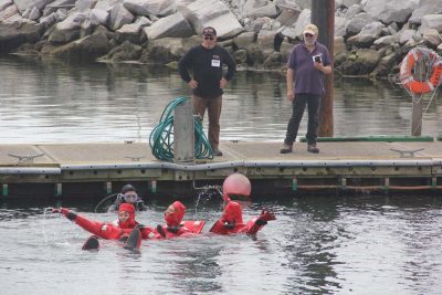 Trainees are taught to form a chain to swim towards the life raft.