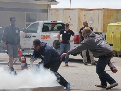 Fishermen practice extinguishing a fire.
