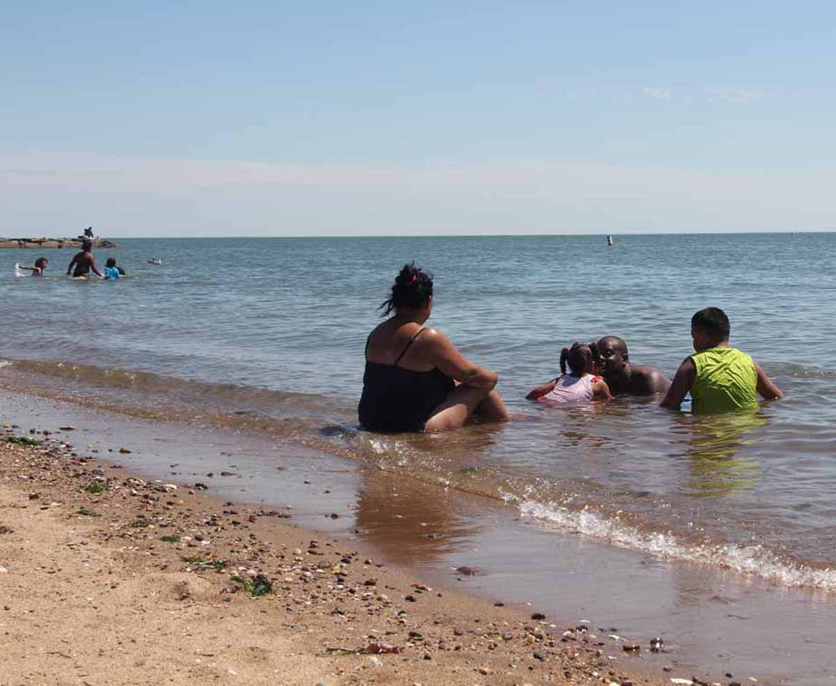 David Hill, center, plays with his three-year-old daughter Makenna, as Jackie Ruiz, right, and her 12-year-old son Jaiden Fretyes look on. The foursome, from the Springfield, Mass., area, spent a sunny July afternoon at Lighthouse Point Park in New Haven. Judy Benson / Connecticut Sea Grant