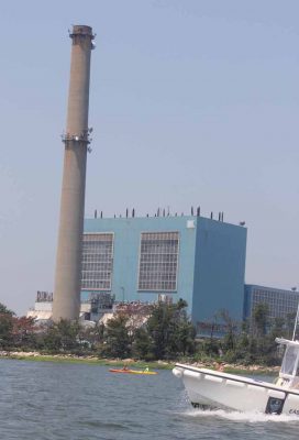 Kayakers and a power boat pass the deactivated Manresa Island coal plant in Norwalk harbor.