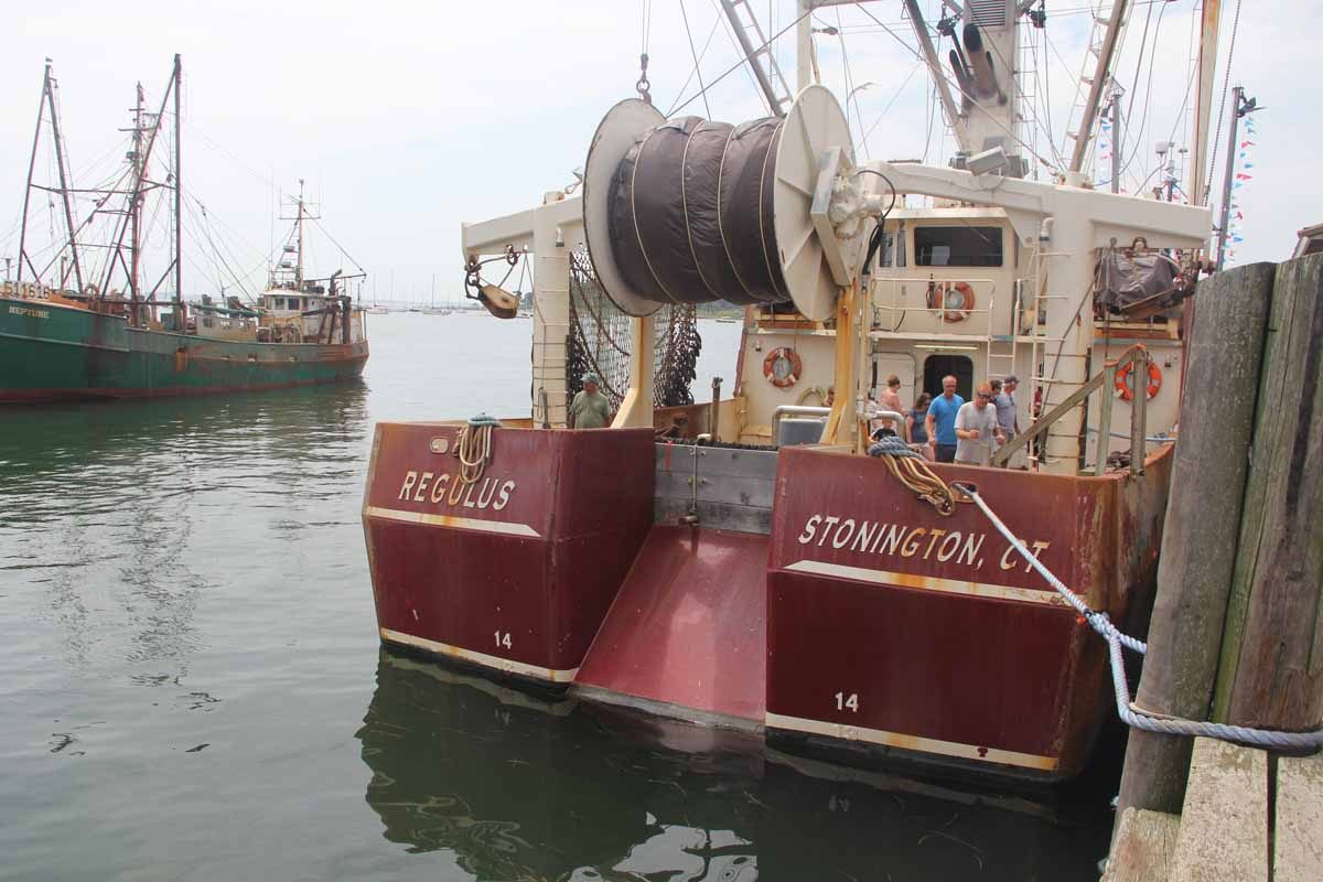 Joe Gilbert, right front, shows leads visitors on a tour of his scallop boat Regulus.