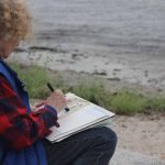 Mary Horrigan of Marlborough painted with water colors near a small sandy beach next the the Marine Sciences Building.