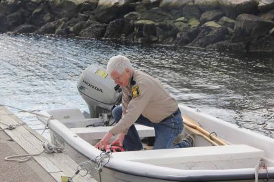 Richard Conant, deputy shellfish warden for Groton, checks the fuel in the boat he uses to collect water samples from the town's recreational shellfishing beds.