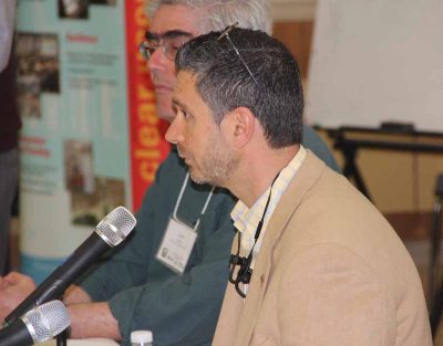 Michael Pacucilla, director of health for the East Shore District Health Department, talks about West Nile virus during a panel discussion. Behind him is University of Rhode Island Prof. Jose Amador.