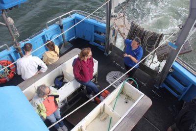 A Project Oceanology crew member answers a question from one of the passengers as the vessel approaches the docks at Avery Point.