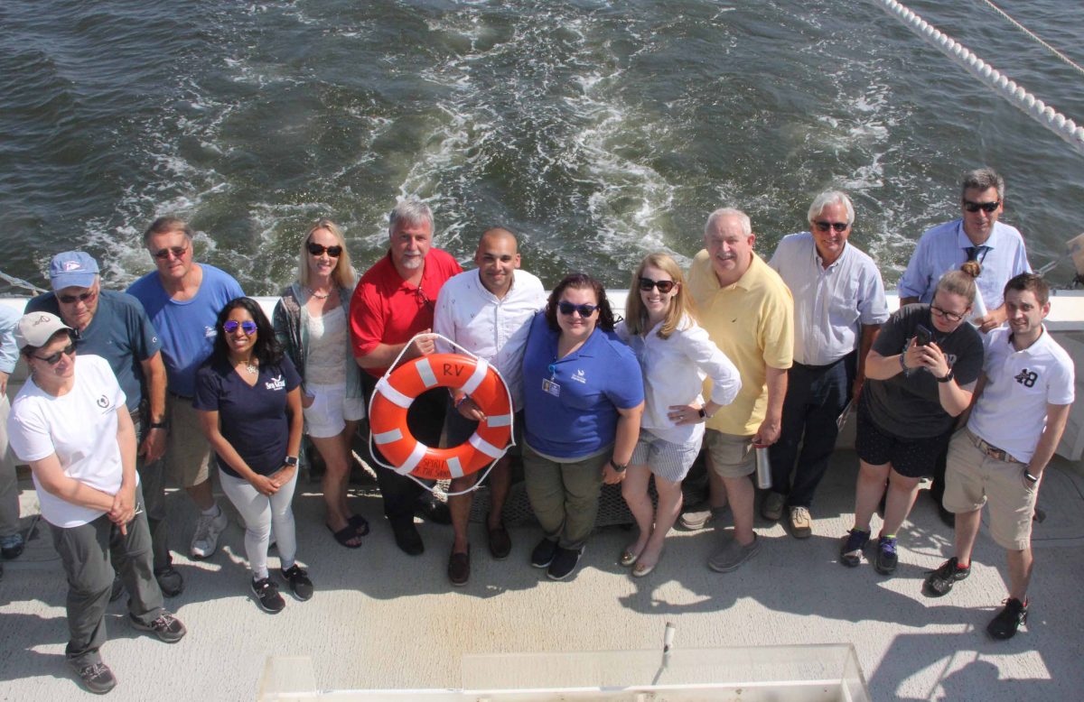Speakers and guests gather on the deck as Spirit of the Sound approaches the docks at the Maritime Aquarium of Norwalk.