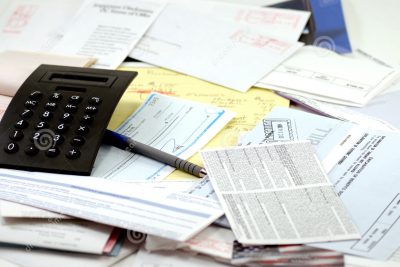 Image of paycheck, calculator and other budgeting tools.