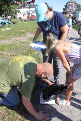 Rob DuPont-Sears of Secor Subaru weighs trash collected by some of the volunteers. Secor Subaru was one of the sponsors of the cleanup.