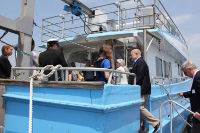 NOAA Administrator Richard Spinrad, center, steps onto the Project Oceanology vessel ahead of CT Sea Grant Director Sylvain De Guise for the tour of CT NERR properties.