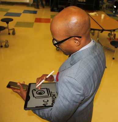 Artist Raheem Nelson draws on an iPad to illustrate one of the workshop discussions.