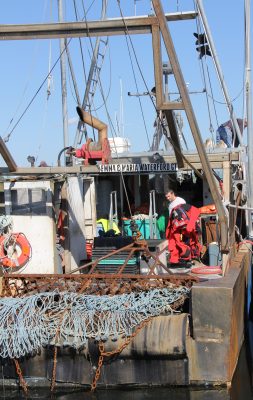A fisherman brings immersion suits onto the deck during an abandoned ship drill aboard the fishing vessel Emma & Maria.