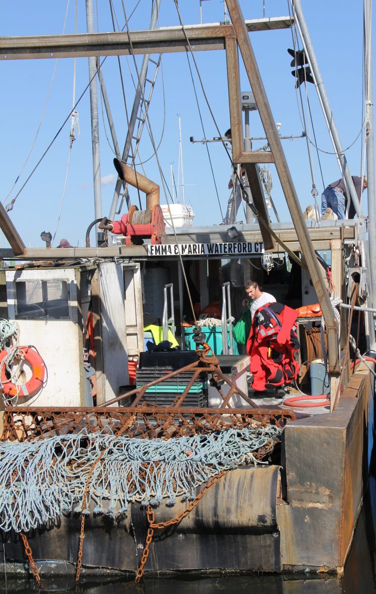 A fisherman brings immersion suits onto the deck during an abandoned ship drill aboard the fishing vessel Emma & Maria.