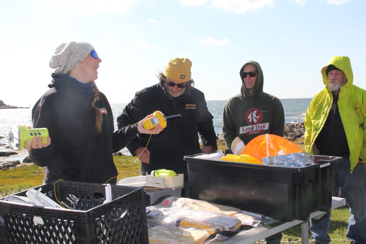 Instructor Shannon Eldredge describes how to use an EPIRB (Emergency Position Indicating Radio Beacon) during the training as fisherman Dan Russell, far right, and others listen.