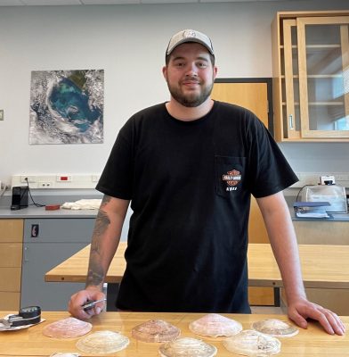 Brendon Goulette measures scallop shells in Samantha Siedlecki’s lab at the UConn Avery Point campus.