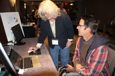 Tammy Warner, who developed a business planning tool for growing kelp with CTSG's Robert Pomeroy, demonstrates the tool to a prospective farmer at the Seaweed Showcase.