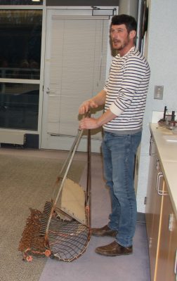 Michael Gilman, aquaculture extension assistant for CT Sea Grant, showes one type of oyster dredge during the new "Foundations of Shellfish Farming" class.