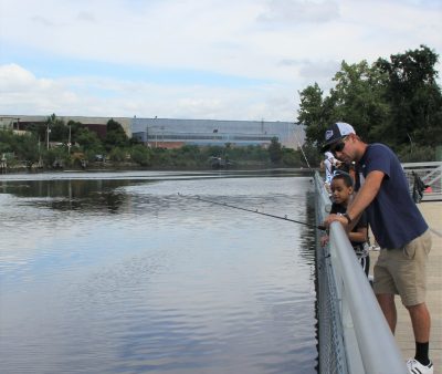 Volunteer David Roberts watches with J.J. James for a bite on his fishing line.