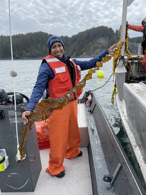 Anoushka Concepcion on a vessel holding a ribbon of kelp.