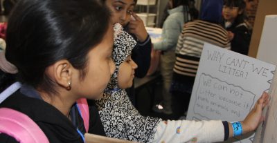 Students from PS 583 in the Bronx, N.Y., hang aposter they created about one of their Long Island Sound Schools Network projects.